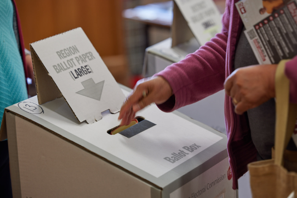 Close up of hand place ballot paper in ballot box